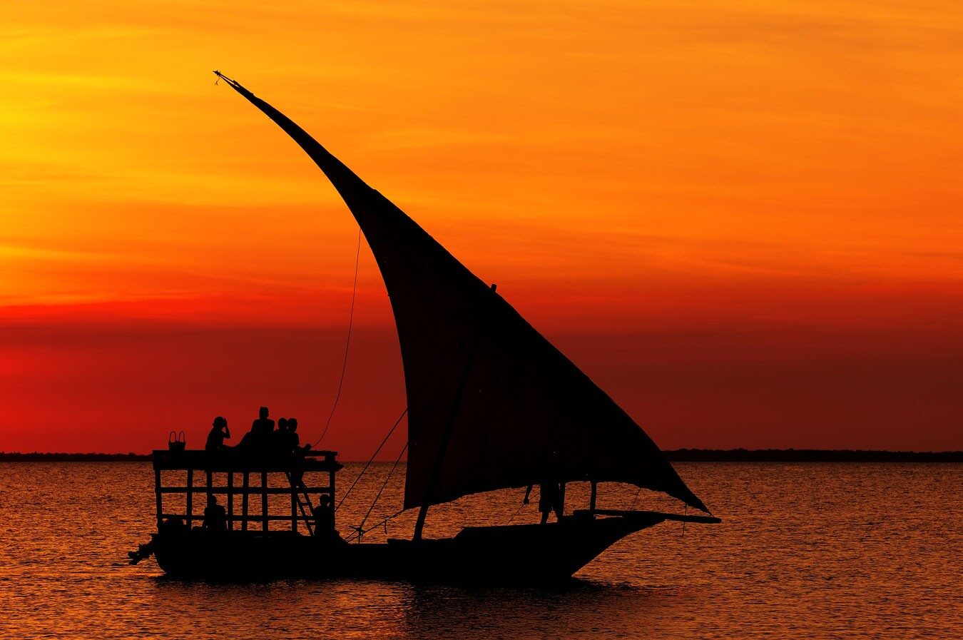 Traditional dhow sailing during a golden Indian Ocean sunset near Kendwa Beach in Zanzibar